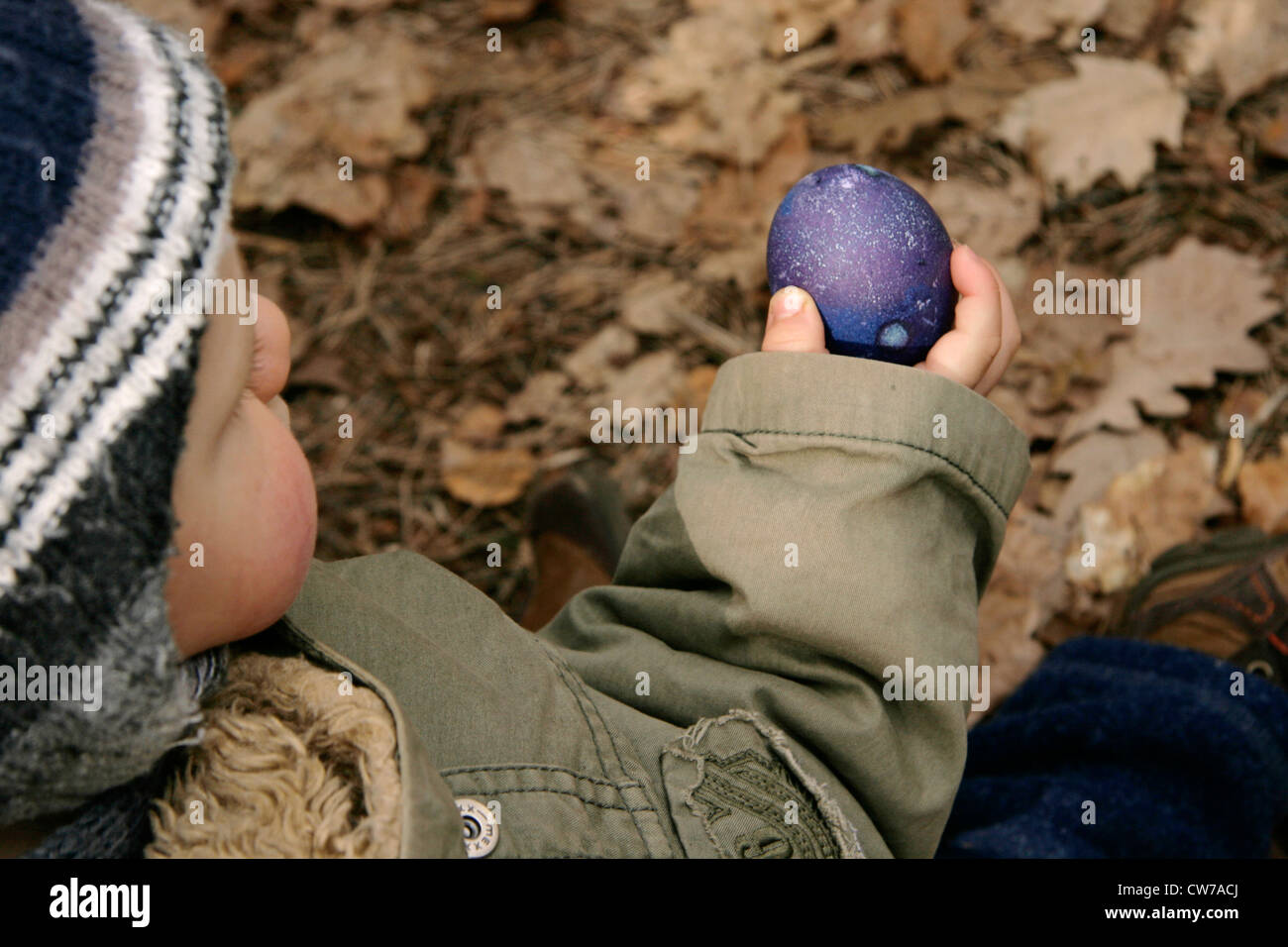 kleiner Junge hält ein Osterei in der Hand, Deutschland Stockfoto
