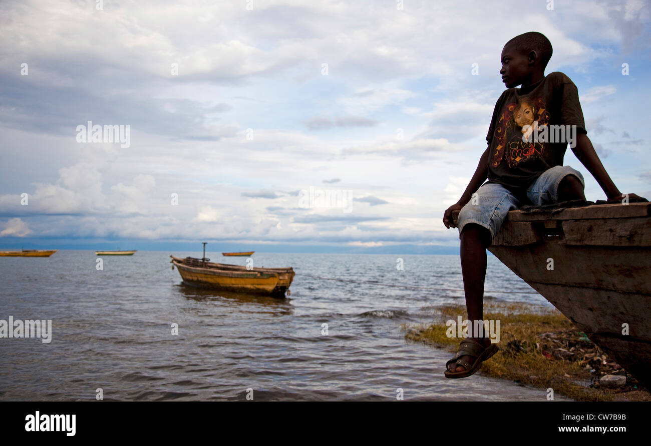 Junge sitzt auf Fischerboot am Tanganjikasee, Burundi, Makamba, Mvugo, Nyanza Lac Stockfoto