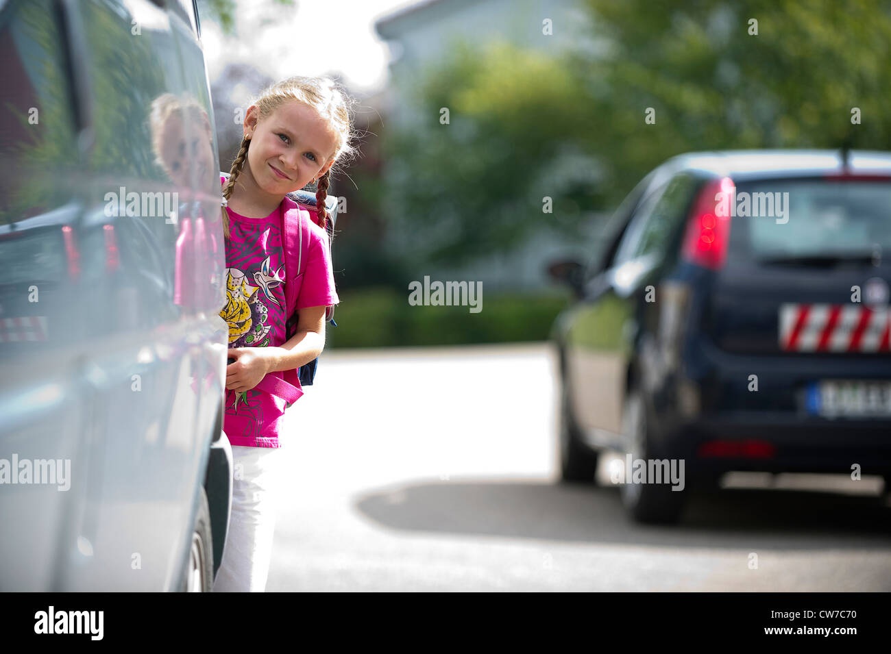 Schulmädchen auf einer Straße hinter einem Auto, Deutschland Stockfoto