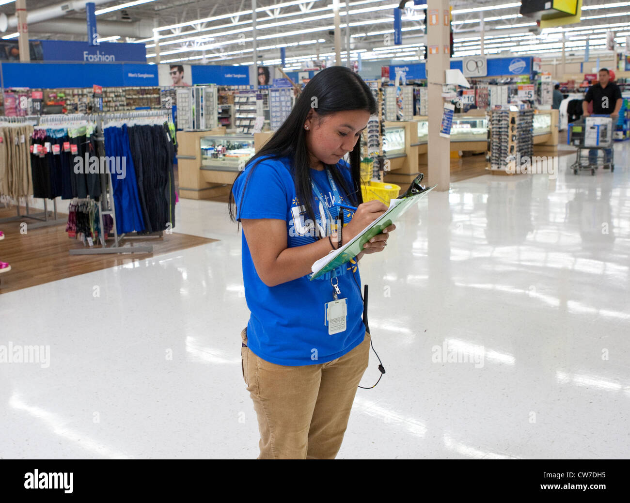 Junge weibliche Angestellte schreibt Bestandsinformationen an ein Wal-Mart Supercenter in San Marcos, Texas Stockfoto