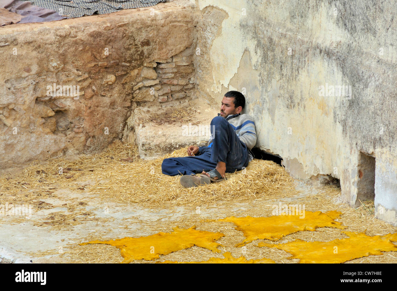 ein junger Mann Ruhe nächste gefärbte Tierhäuten in Gerberei Chouwara, Marokko, Fes Stockfoto