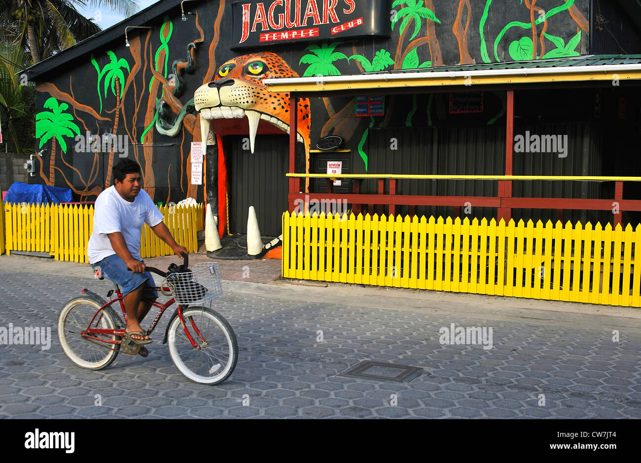 Mann auf einem Fahrrad vorbei ein Nachtclub, Belize Stockfoto