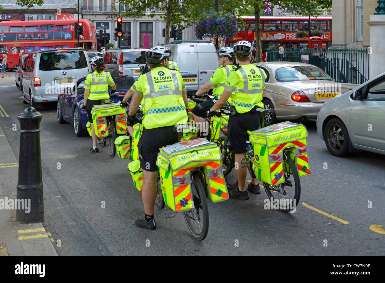 St. John Ambulance High viz Gruppe erste Hilfe Zyklus Freiwillige Responder Menschen in Trafalgar Square auf Fahrräder hohe Sichtbarkeit Jacke Und Fahrradtaschen London UK Stockfoto