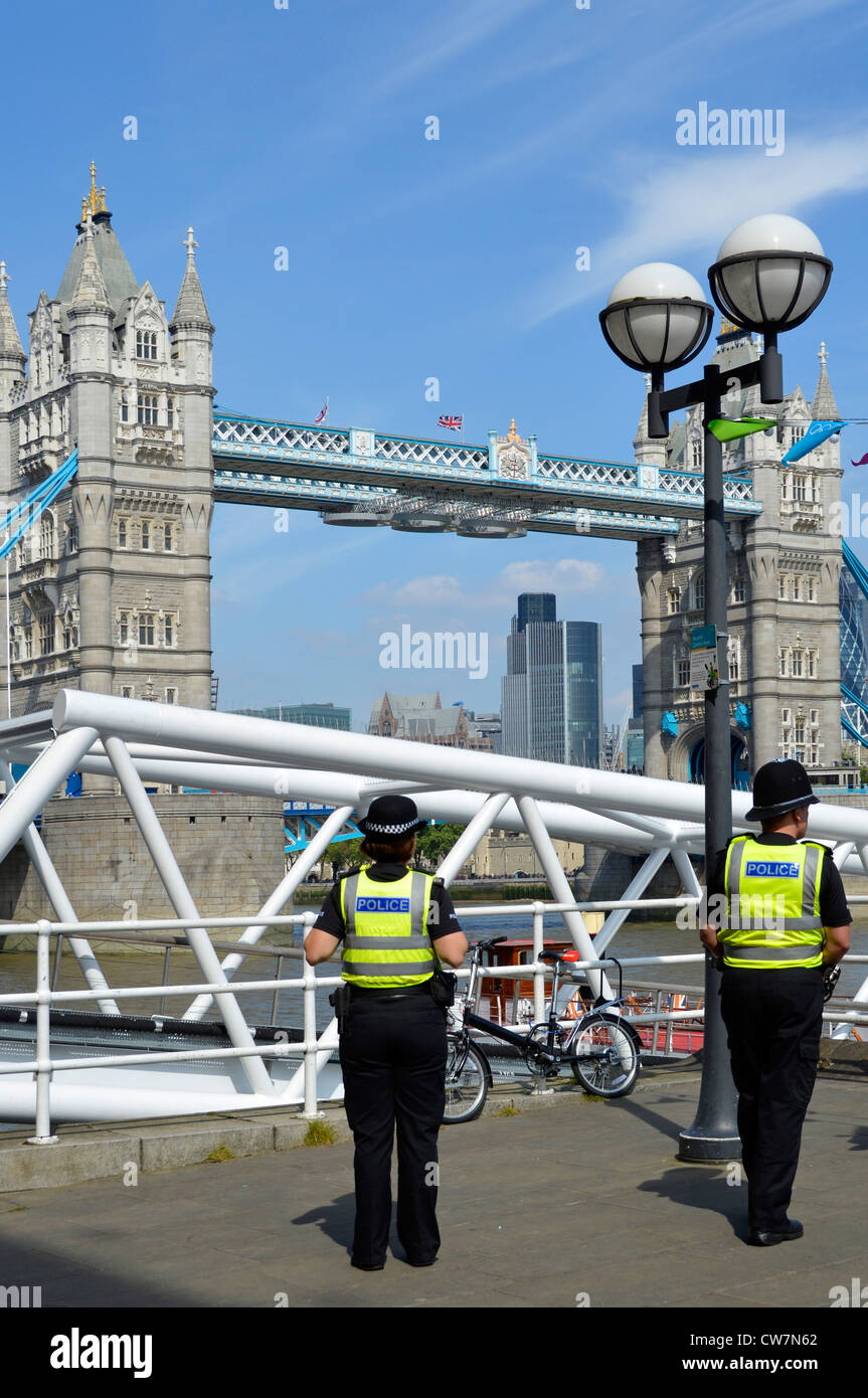 Rückansicht zwei städtische Polizeibüros, eine Polizistin und ein Polizist auf Sommerfußpatrouille nahe Tower Bridge Southwark London England UK Stockfoto