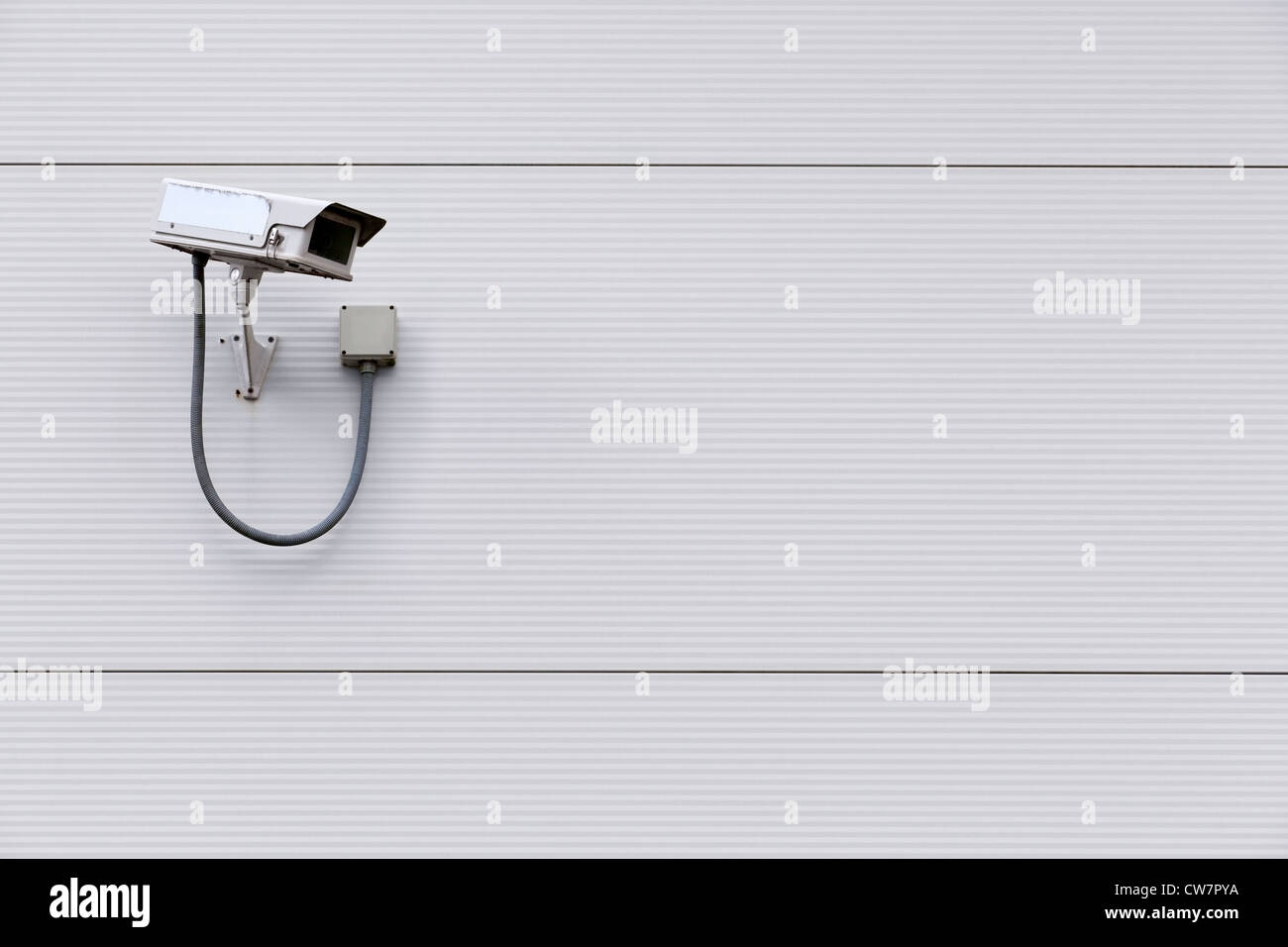 Foto von einer Überwachungskamera an der Wand eines Gebäudes mit textfreiraum für Text. Stockfoto