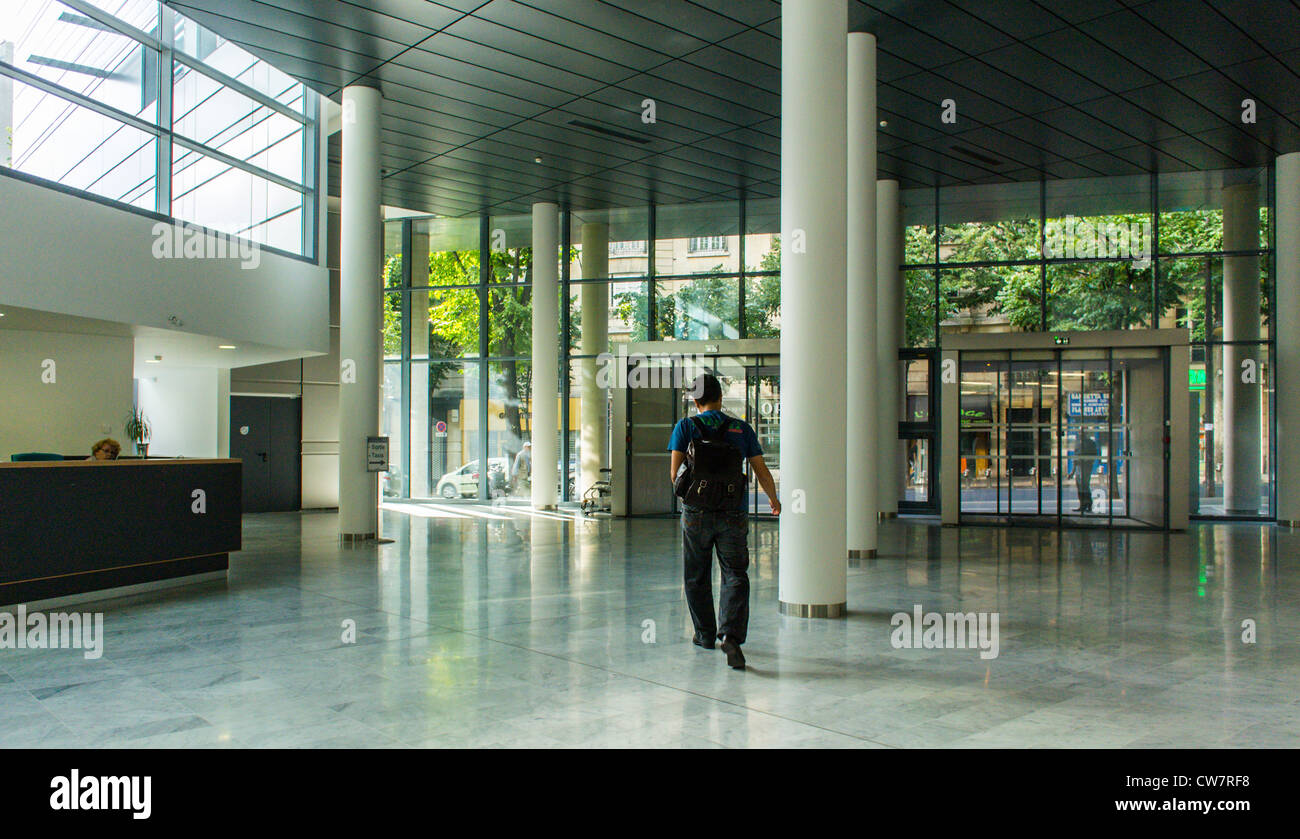 Paris, Frankreich, Französische Öffentliche Krankenhäuser, Moderne Architektur, Hopital Tenon, Im Hauptflur, Mann, Der Weg Geht, Einsamkeit. Konzeptuelles Bild der Einsamkeit dargestellt durch die Silhouette eines Mannes, der einen Flur hinuntergeht, Wide View, Hall, französisches öffentliches Krankenhaus Stockfoto