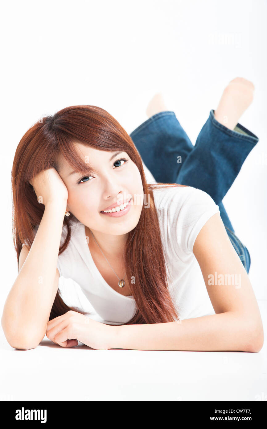 Schöne asiatische Frau, die auf dem Boden liegend Stockfoto