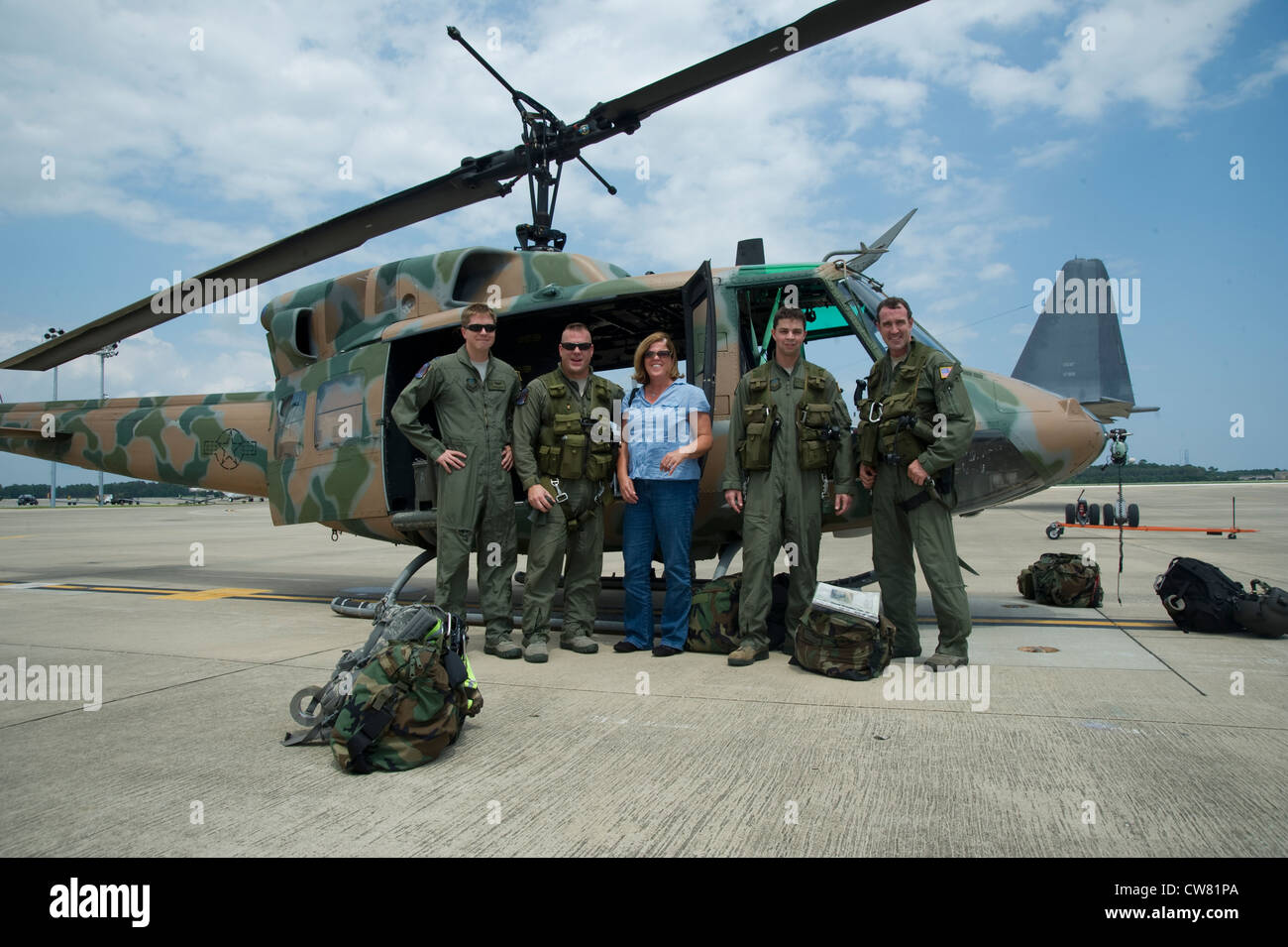 Von links US Air Force Capt. James Rankin, U.S. Air Force Chief Master Sgt. Daniel Leick, Rhonda Gritsavage, US Air Force Capt. David Lee und U.S. Air Force Senior Master Sergeant Clint Grizzell stehen vor einem UH-1N Huey Gunship auf der Fluglinie des Hurlburt Field, Florida, Aug. 13. Die Huey wird von der 6. Special Operations Squadron geflogen, um ihre Mission zu unterstützen, ausländische Luftstreitkräfte bei der Beschäftigung, dem Erhalt und der Integration von Luftstreitkräften zu bewerten, auszubilden, zu beraten und zu unterstützen. Stockfoto