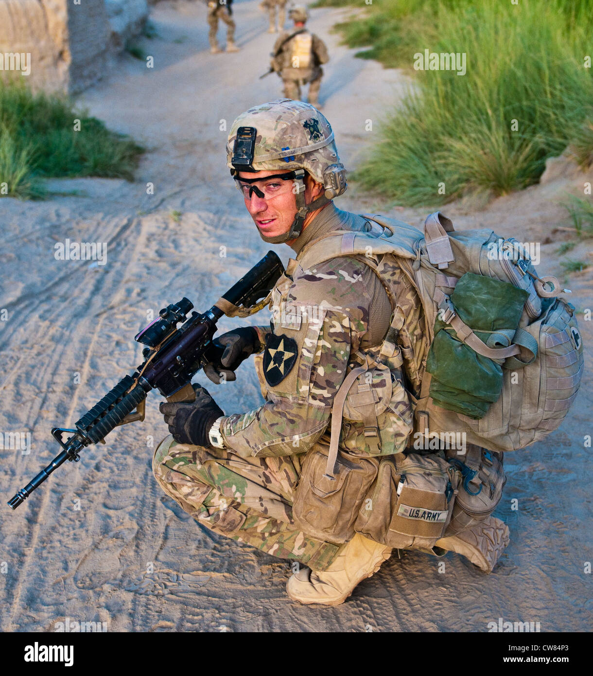 Spc. Blaine Templeton der Zugmediziner mit dem 2. Zug, Apache Company, 1. Bataillon, 23. Infanterie-Regiment, knielte während einer Fußpatrouille in einem kleinen Dorf im Süden Afghanistans, 1. August 2012. Stockfoto
