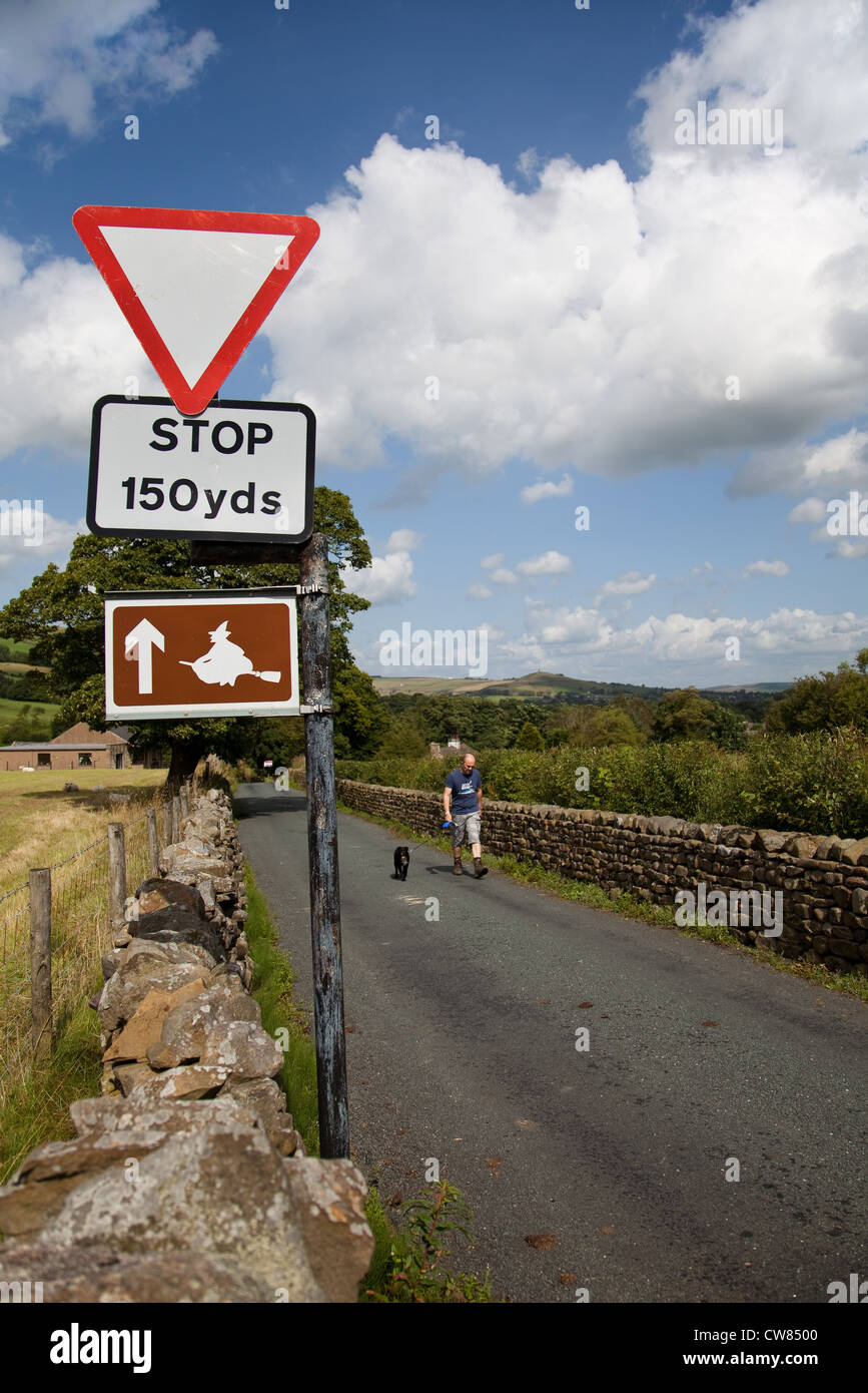 Stop-Schild, und Touristische Informationen Hexe auf Besen. Am Straßenrand Witchway marker Land Zeichen in der Nähe von Pendle, Roughlee, Lancashire, Großbritannien Stockfoto