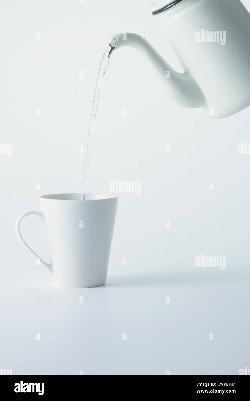 Wasser gießen in Tasse Stockfoto