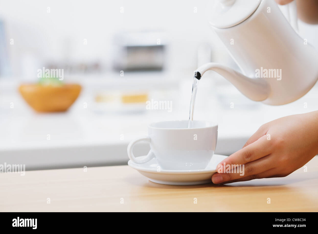 Wasser gießen in Tasse Stockfoto