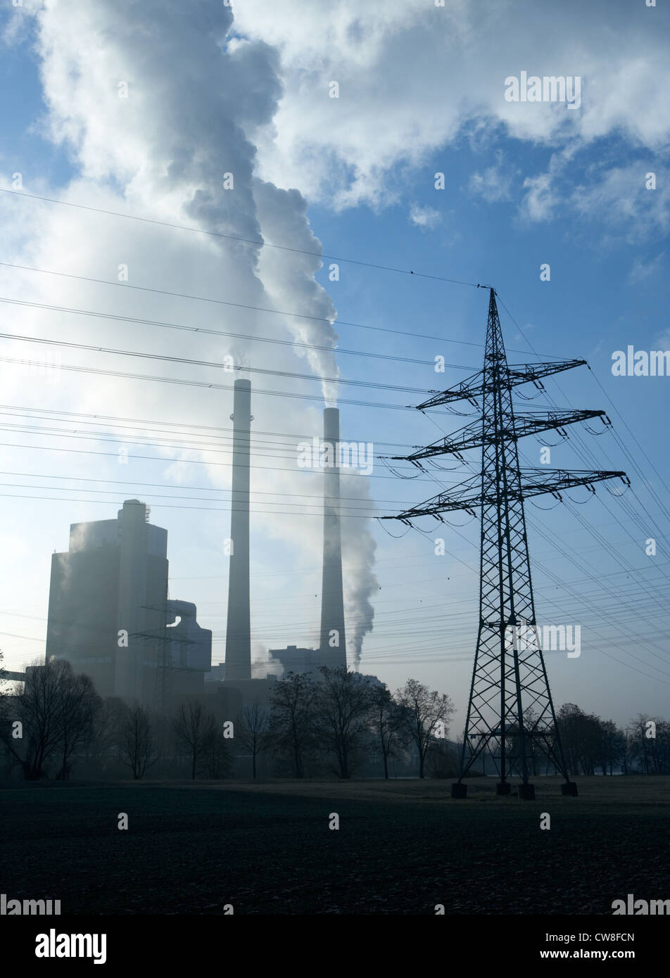 Kohle-Kraftwerk mit Rauch und Dampfwolken im Gegenlicht Stockfoto