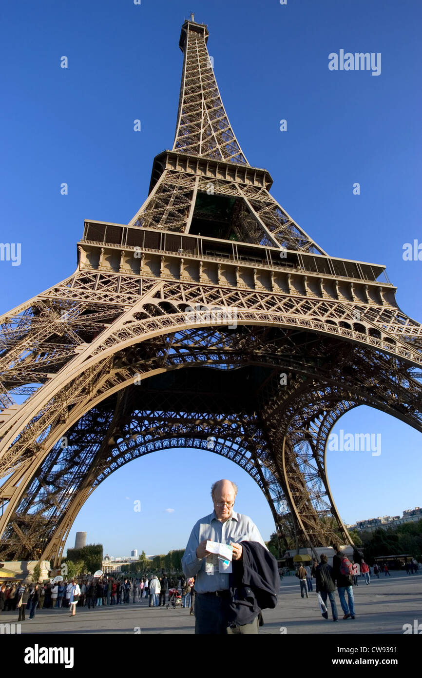 Paris, unter dem Eiffelturm ein Tourist schaut auf einer Karte Stockfoto