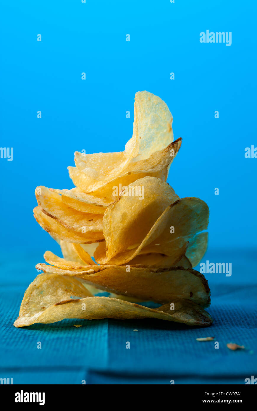 Kartoffel-Chips Stapel auf blauem Hintergrund mit Textfreiraum Stockfoto