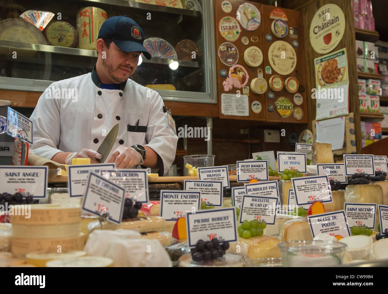 Hoboken, New Jersey - schneidet ein Arbeiter Käse an Aspen Marktplatz, ein Gourmet-Lebensmittel-Shop. Stockfoto