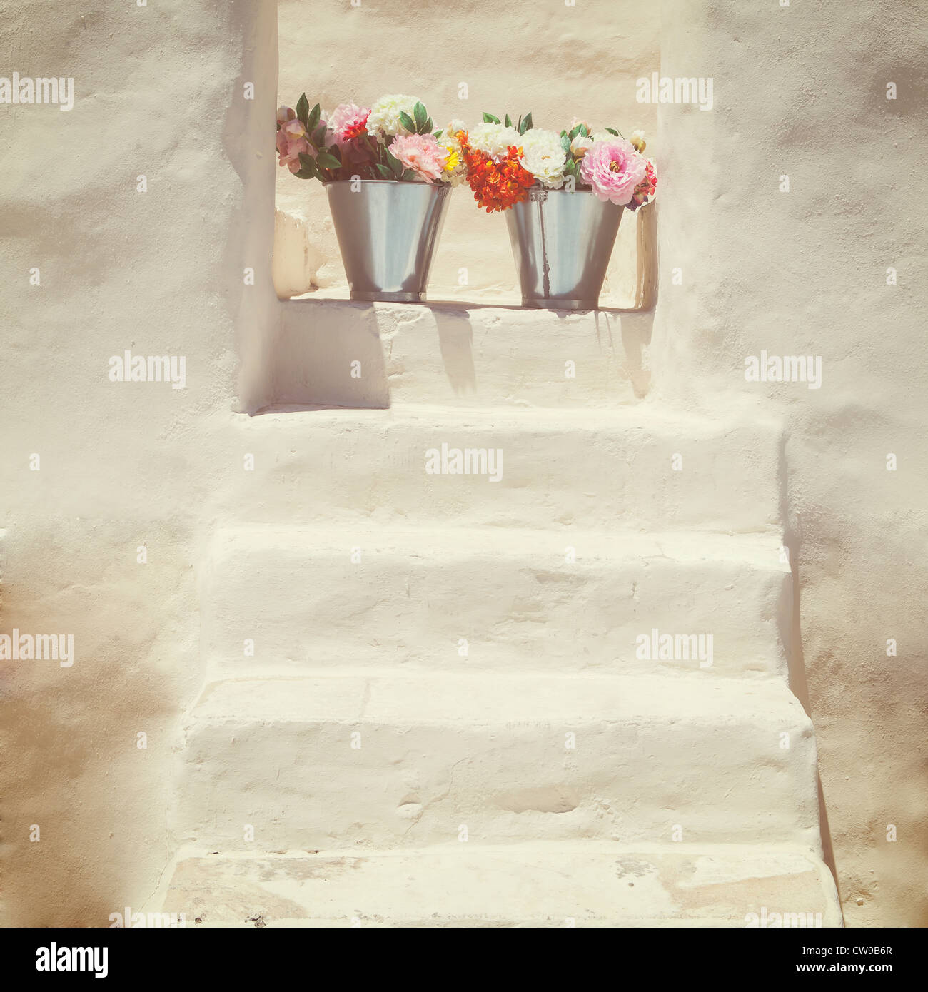 Eine Treppe mit einem Griechen, weißes Haus mit zwei Blumensträuße Stockfoto