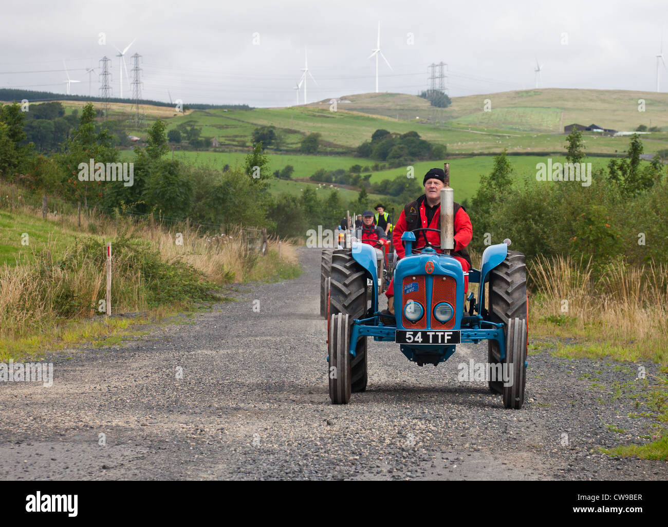 Enthusiasten aus Ayrshire Oldtimer Traktoren und Maschinen Club während einer Straße laufen. Im Vordergrund befindet sich ein Fordson Dexta Stockfoto