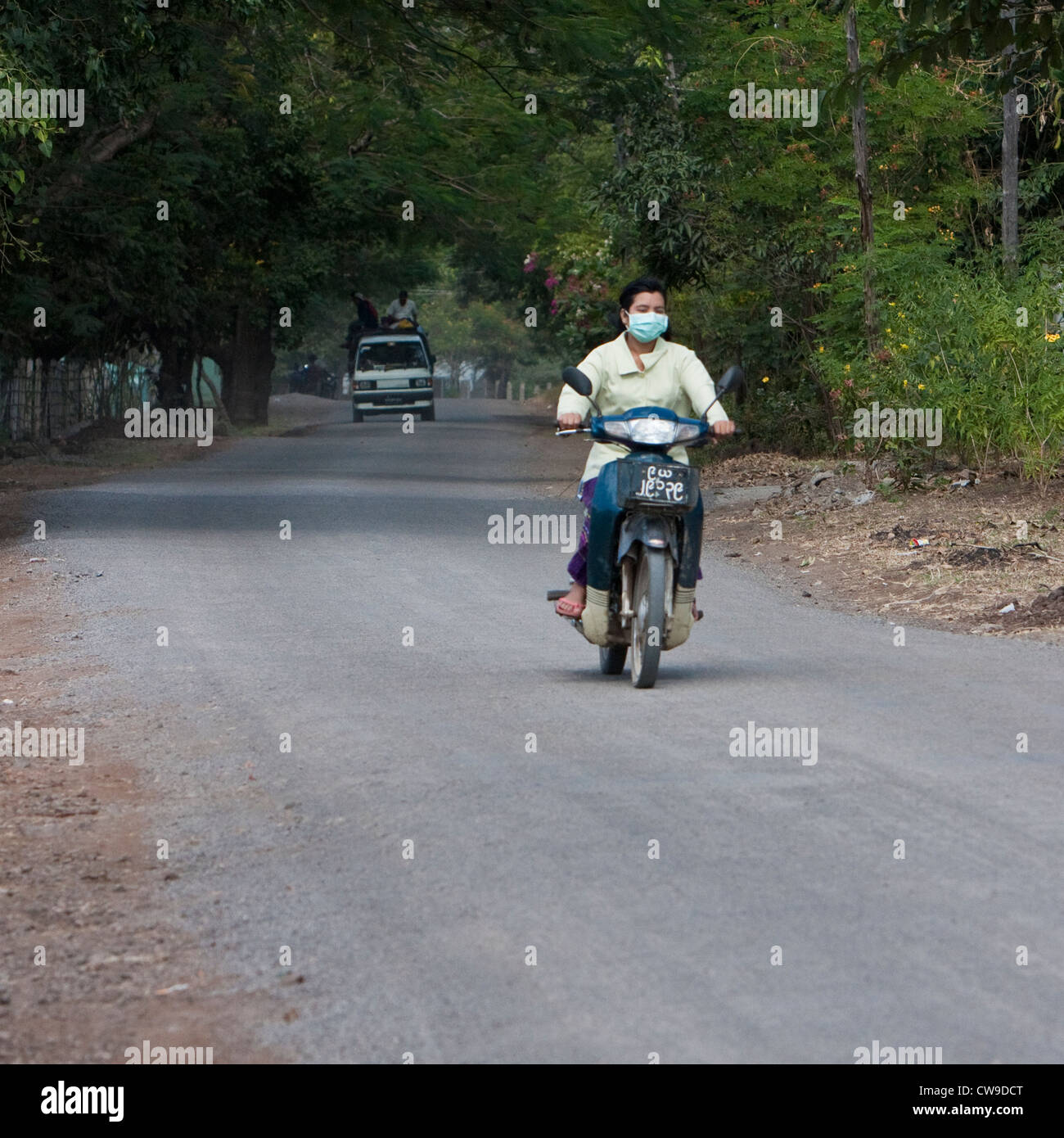 Myanmar, Burma, in der Nähe von Bagan. Motorrad-Fahrer tragen Atmung Maske, kein Helm. Stockfoto