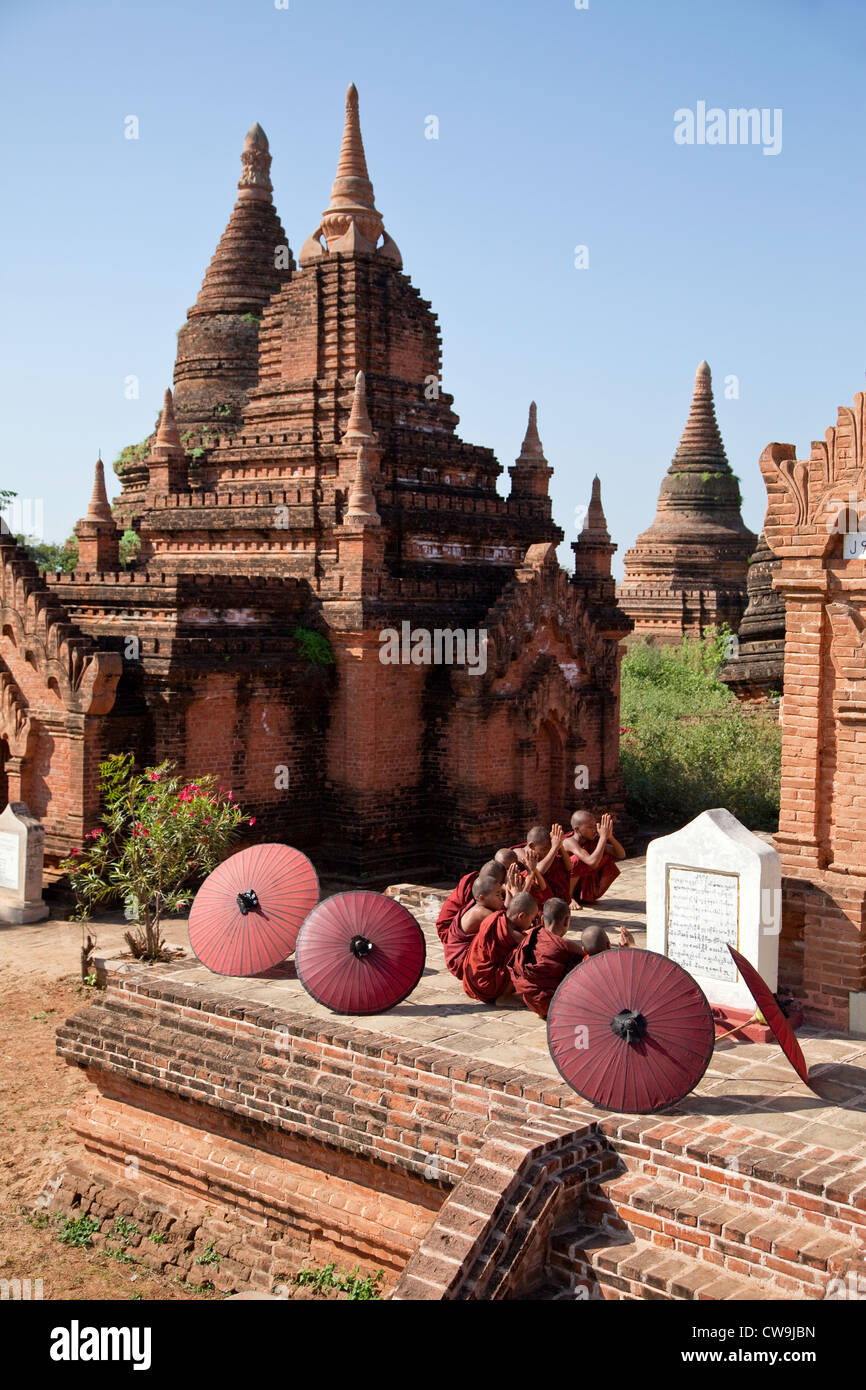 Myanmar, Burma. Bagan. Junge Novizin Mönche beten vor einem Tempel. Stockfoto