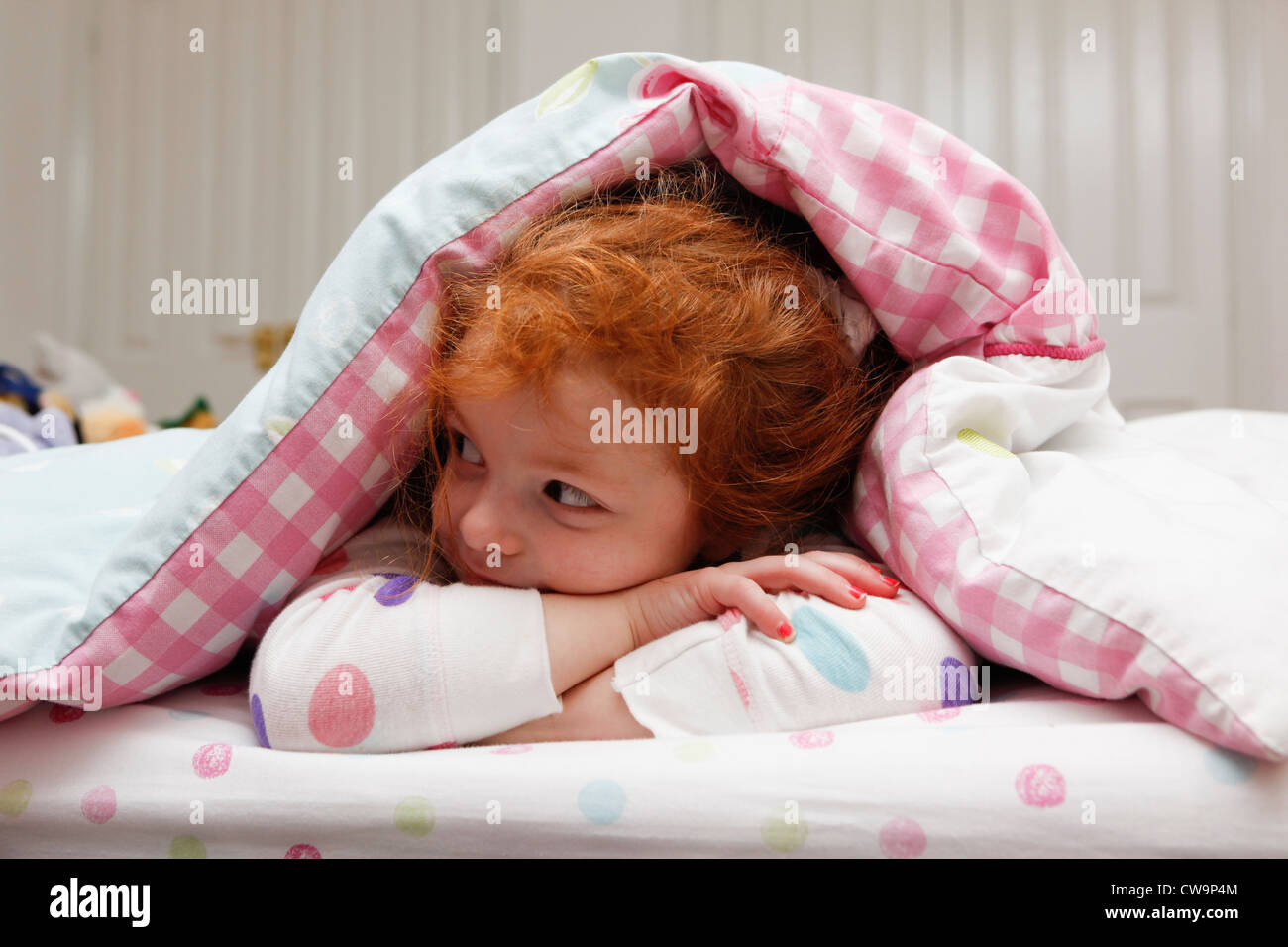 Kleines Mädchen wach im Bett. Stockfoto