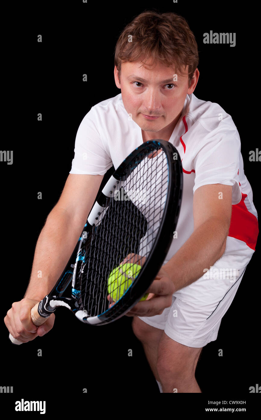 Porträt eines jungen männlichen Tennis-Spieler rund um den Ball über schwarzen Hintergrund dienen Stockfoto
