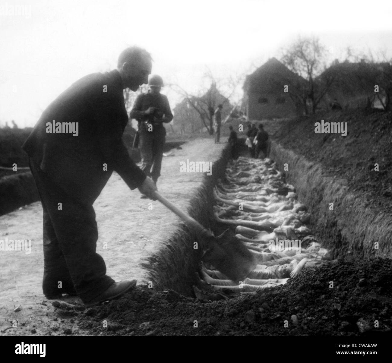 Ein deutscher Zivilist hilft, einige der 2.500 Toten Gefangenen 1945 im Konzentrationslager Nordhausen gefunden begraben. Höflichkeit: CSU Stockfoto
