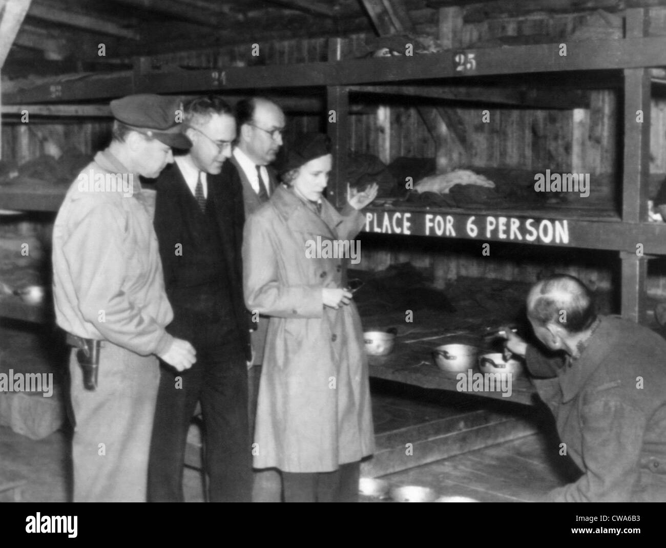 Ein KZ Häftling (rechts) zeigt Leutnant General Hoyt Vandenburg, Kongressabgeordnete John Kunkel und Leonard Hall, und Stockfoto