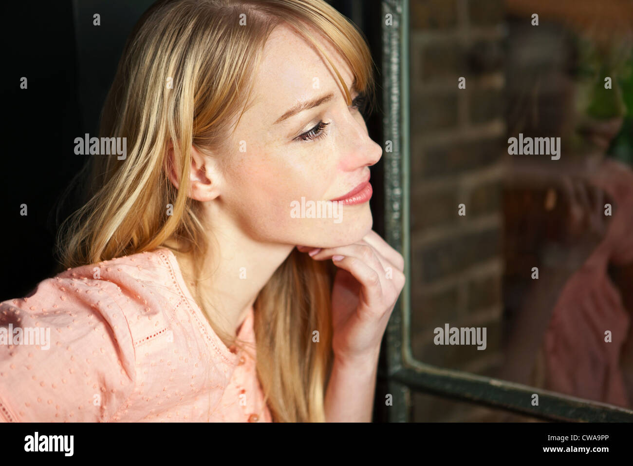 Frau, die durch Fenster, Nahaufnahme Stockfoto
