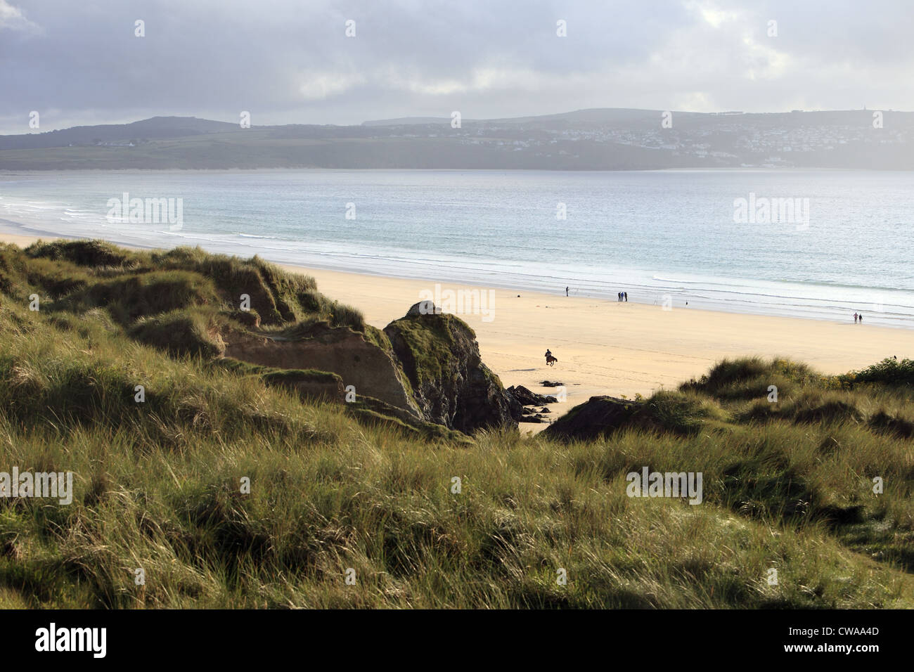 Ein Reiter genießt einen ruhigen Strand bei Ebbe am Strand von Gwithian nach einem Sturm, St. Ives Bay, Cornwall, England, UK Stockfoto