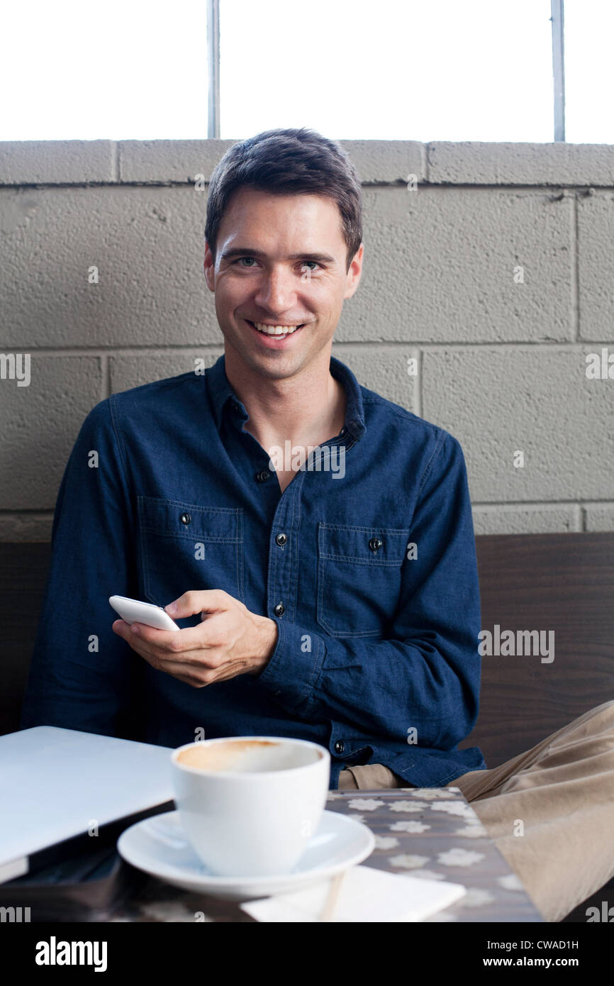 Geschäftsmann mit Smartphone in Café, Porträt Stockfoto