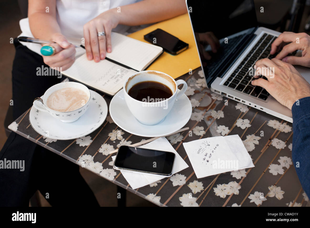 Geschäftsleute in Café, Mann mit Laptop Frau schreiben Stockfoto