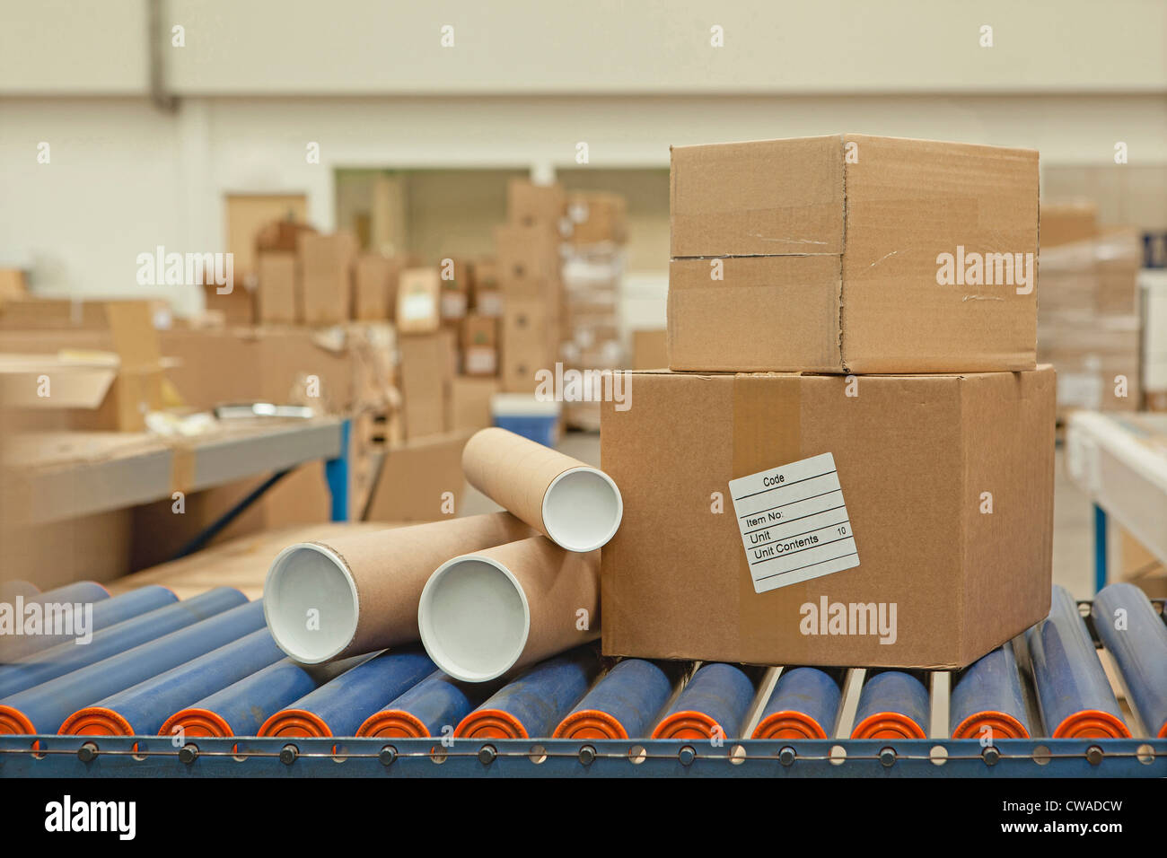 Kartons und Rohre auf Förderband Stockfoto