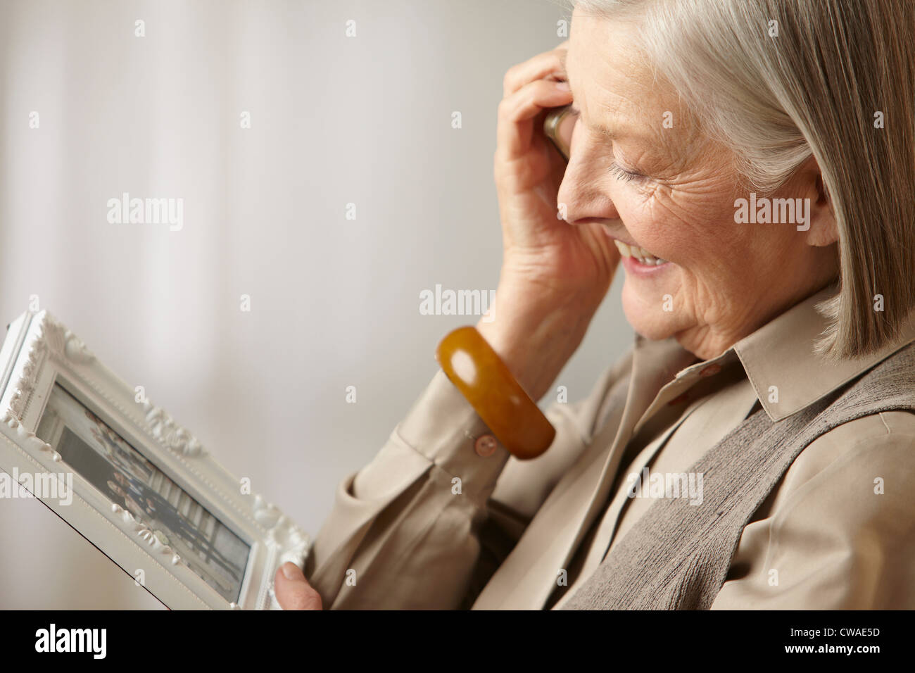 Ältere Frau mit Bilderrahmen Stockfoto