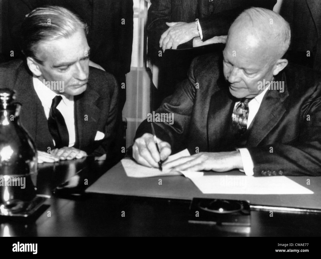 Der britische Premierminister Anthony Eden beobachtet, wie Präsident Dwight D. Eisenhower eine gemeinsame Erklärung über die 3-Tages-Gespräche unterzeichnet Stockfoto