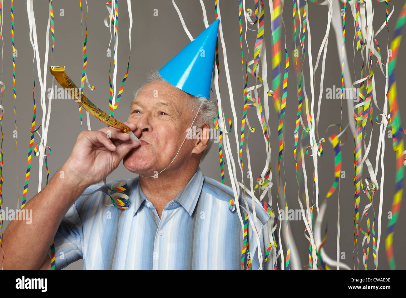 Ältere Mann mit Partei Gebläse und Luftschlangen Stockfoto
