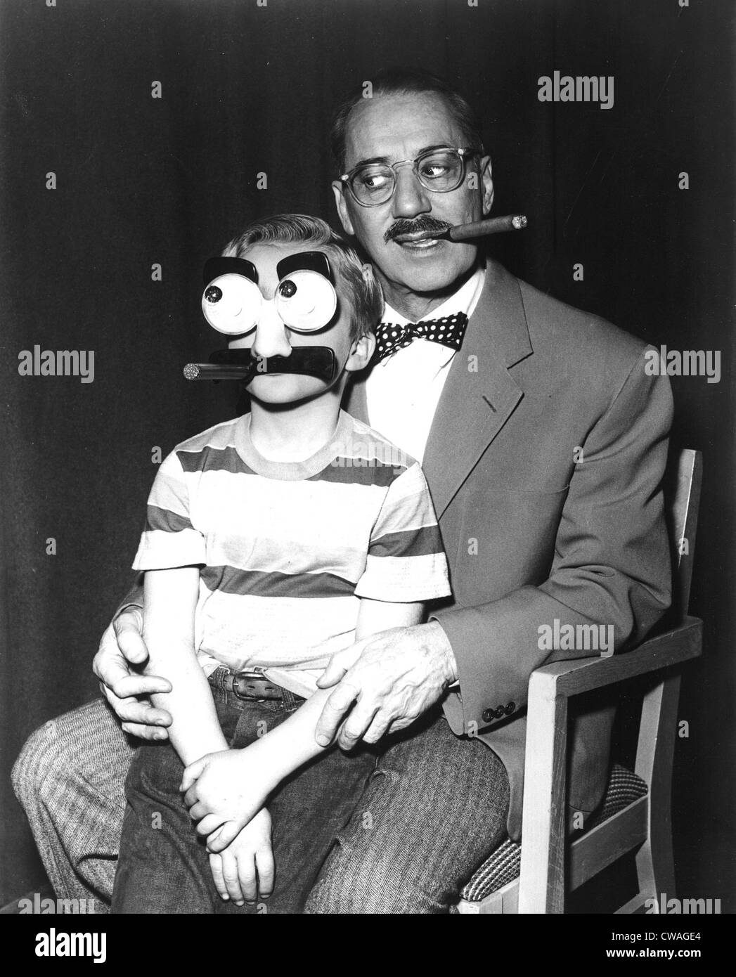 Groucho Marx und ein Kind mit einer Maske Groucho, 1955. Höflichkeit: CSU Archive / Everett Collection Stockfoto