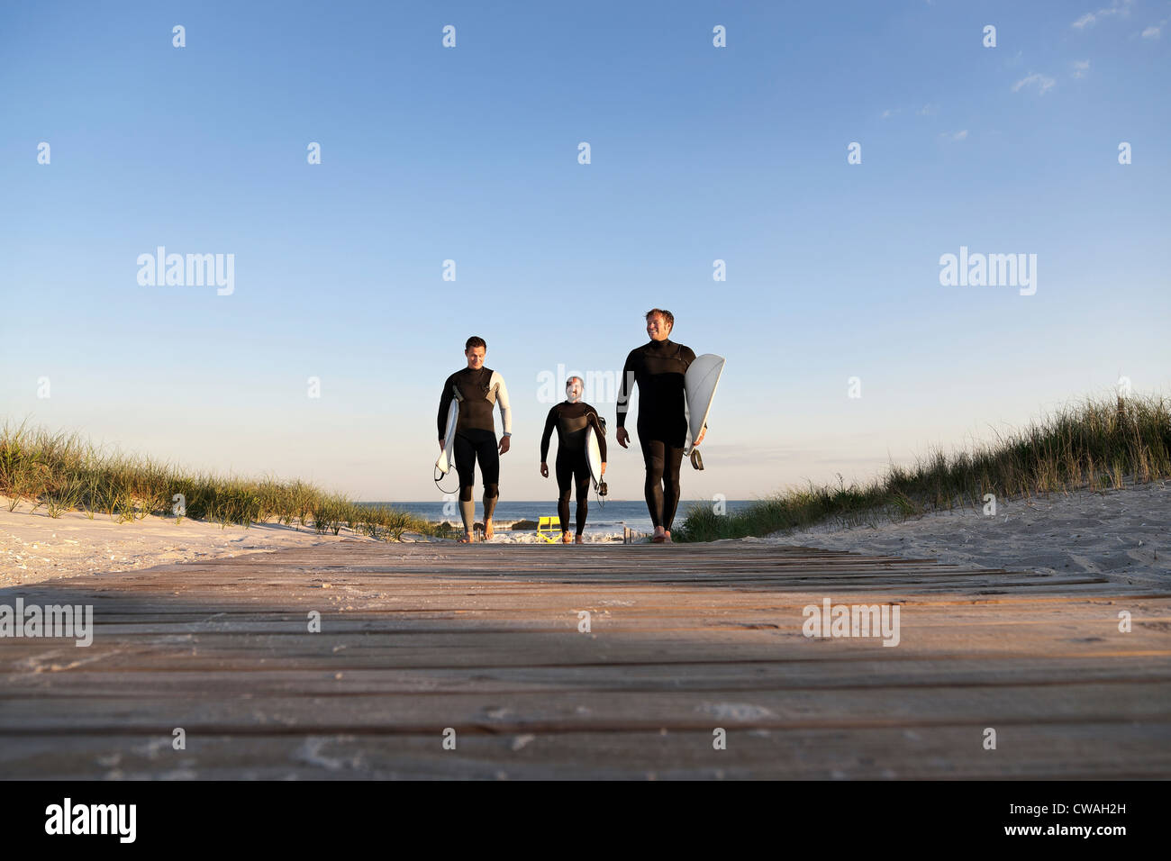Drei Surfer auf Promenade zu Fuß Stockfoto