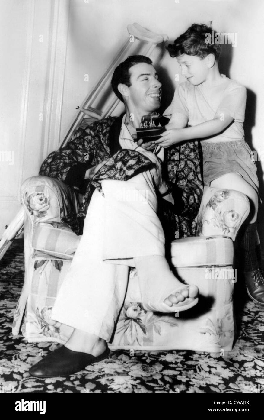 Joe DiMaggio, erholt sich von einer Operation an seiner rechten Ferse seines Sohnes Joe jr. zeigt eine Stauette, die ihm gegeben, als ein Geschenk von der Stockfoto
