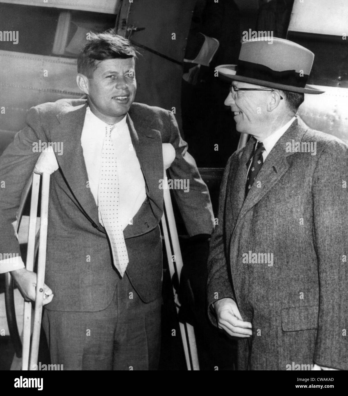 Senator John F. Kennedy, auf Krücken aus einer Kriegszeit Rückenverletzung, Leutnant-Gouverneur von Massachusetts Robert F. Murphy an Logan Stockfoto