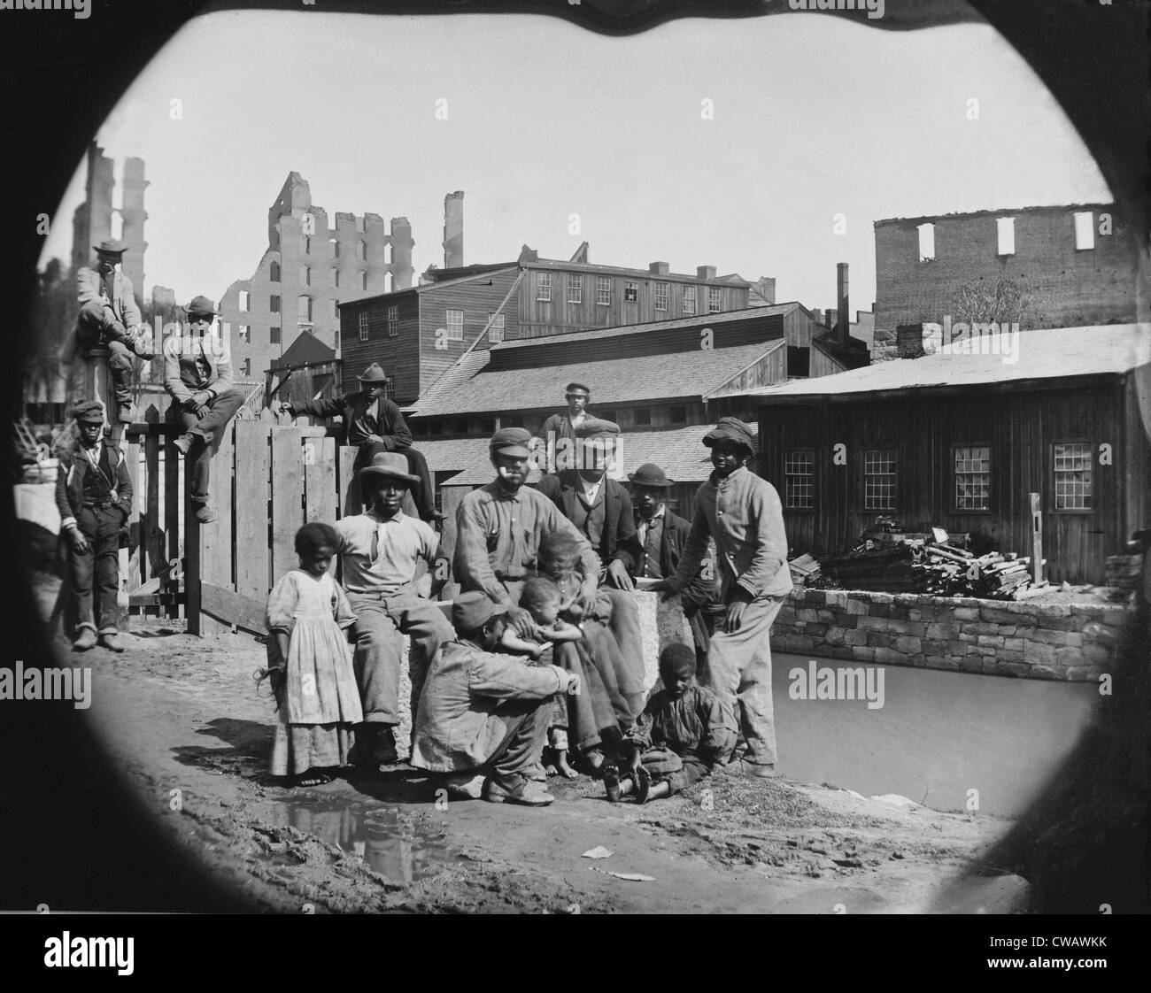 Eine gerade befreiten afrikanischen amerikanischen Gruppe von Männern und ein paar Kinder posieren durch einen Kanal gegen die Ruinen von Richmond, Virginia. Stockfoto