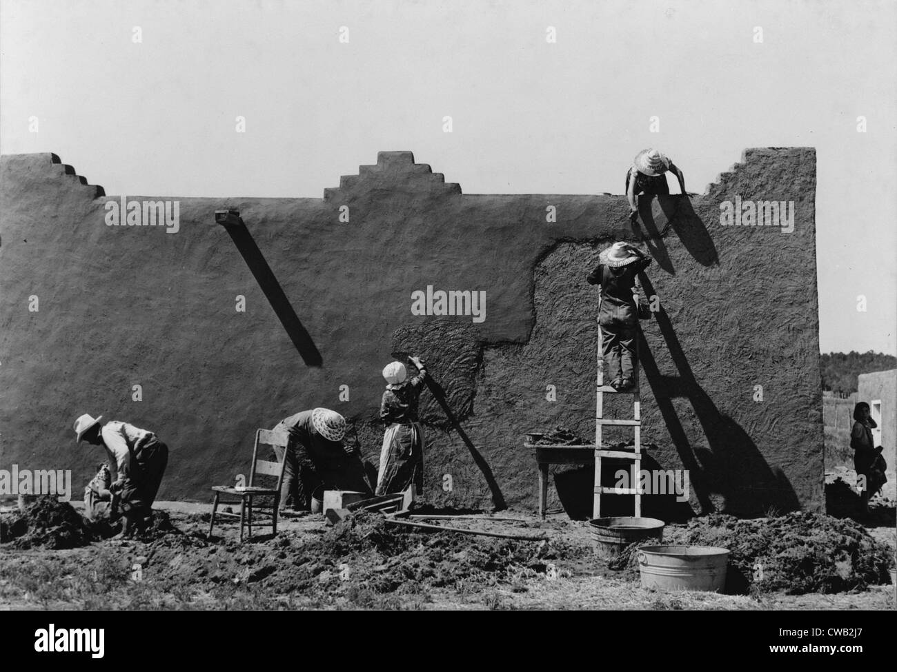 Frauen eine Adobe-Haus, Foto von Lee Russell, Chamisal, New Mexico, Juli 1940 Verputzen. Stockfoto