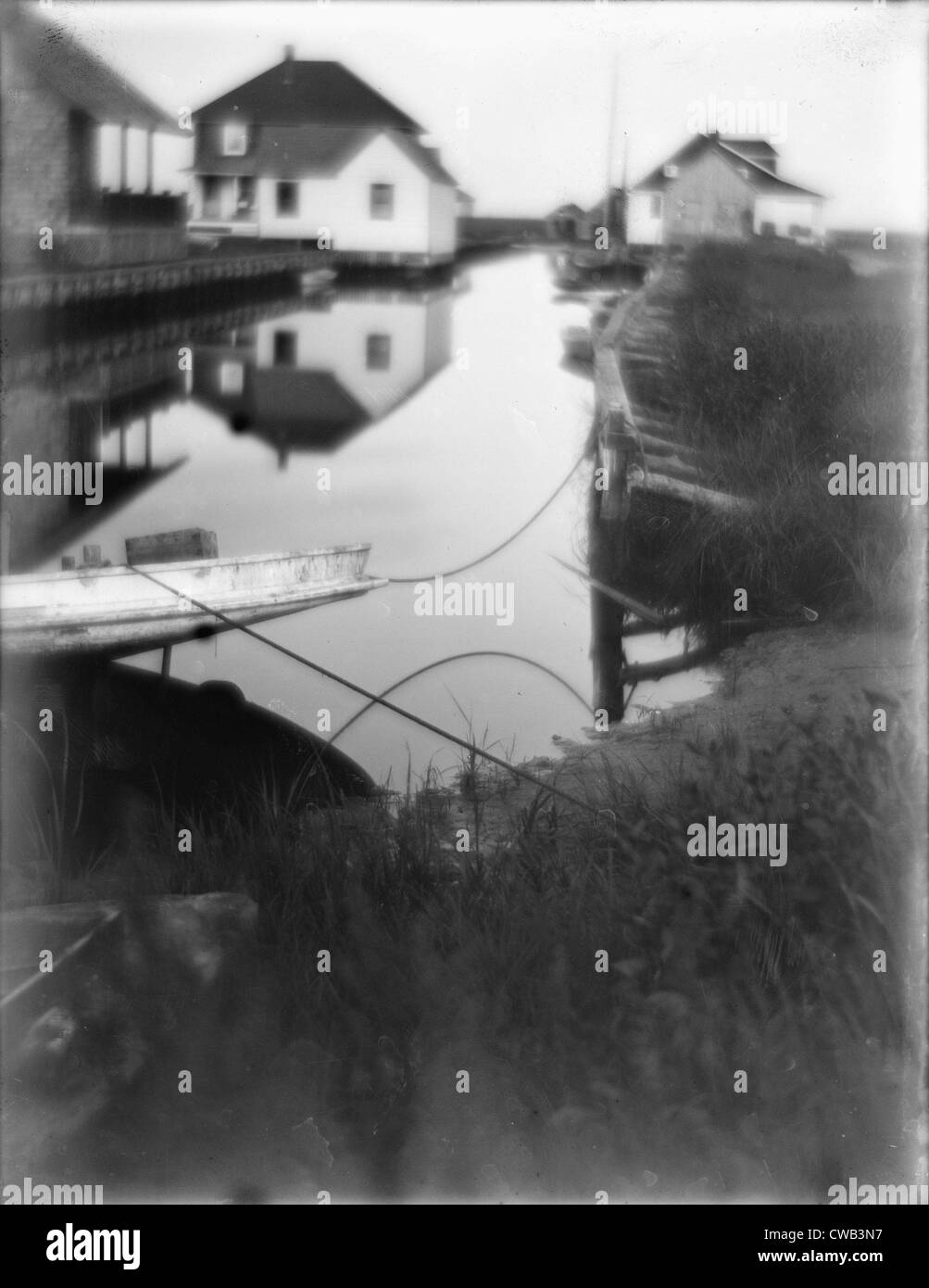 Bungalows am Rand des Wassers in Oceanside, einen kleinen Durchgang des Wassers flankiert von Häusern und Docks, Long Island, New York, Stockfoto