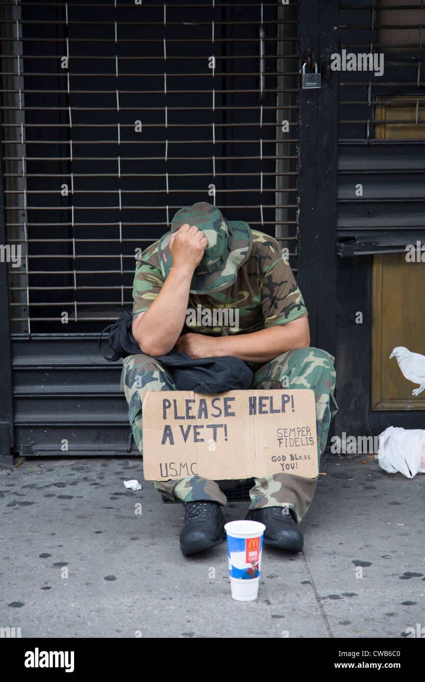 Down and out uns Marine Corp-Veteran betteln um monetäre Hilfe in der 6th Avenue in New York City Stockfoto