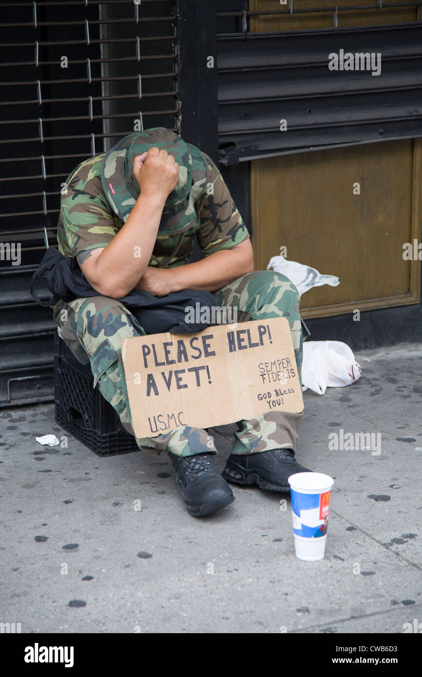 Down and out uns Marine Corp-Veteran betteln um monetäre Hilfe in der 6th Avenue in New York City Stockfoto