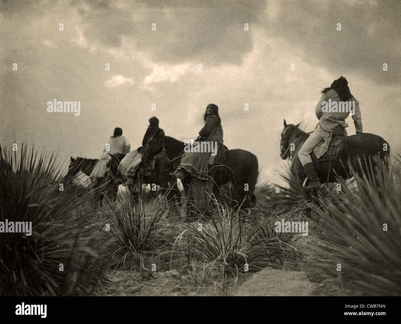 Apachen. Vor dem Sturm - vier Apache auf dem Pferderücken zu Pferd unter Gewitterwolken. Foto von Curtis, 1906 Stockfoto