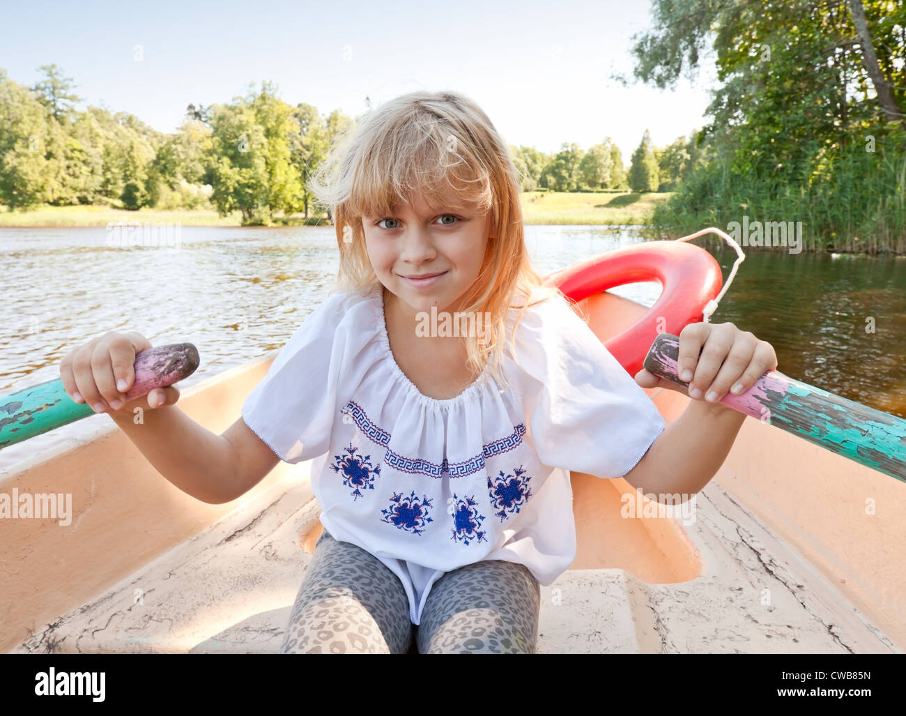 Kleine blonde Mädchen auf dem Boot rudern Stockfoto