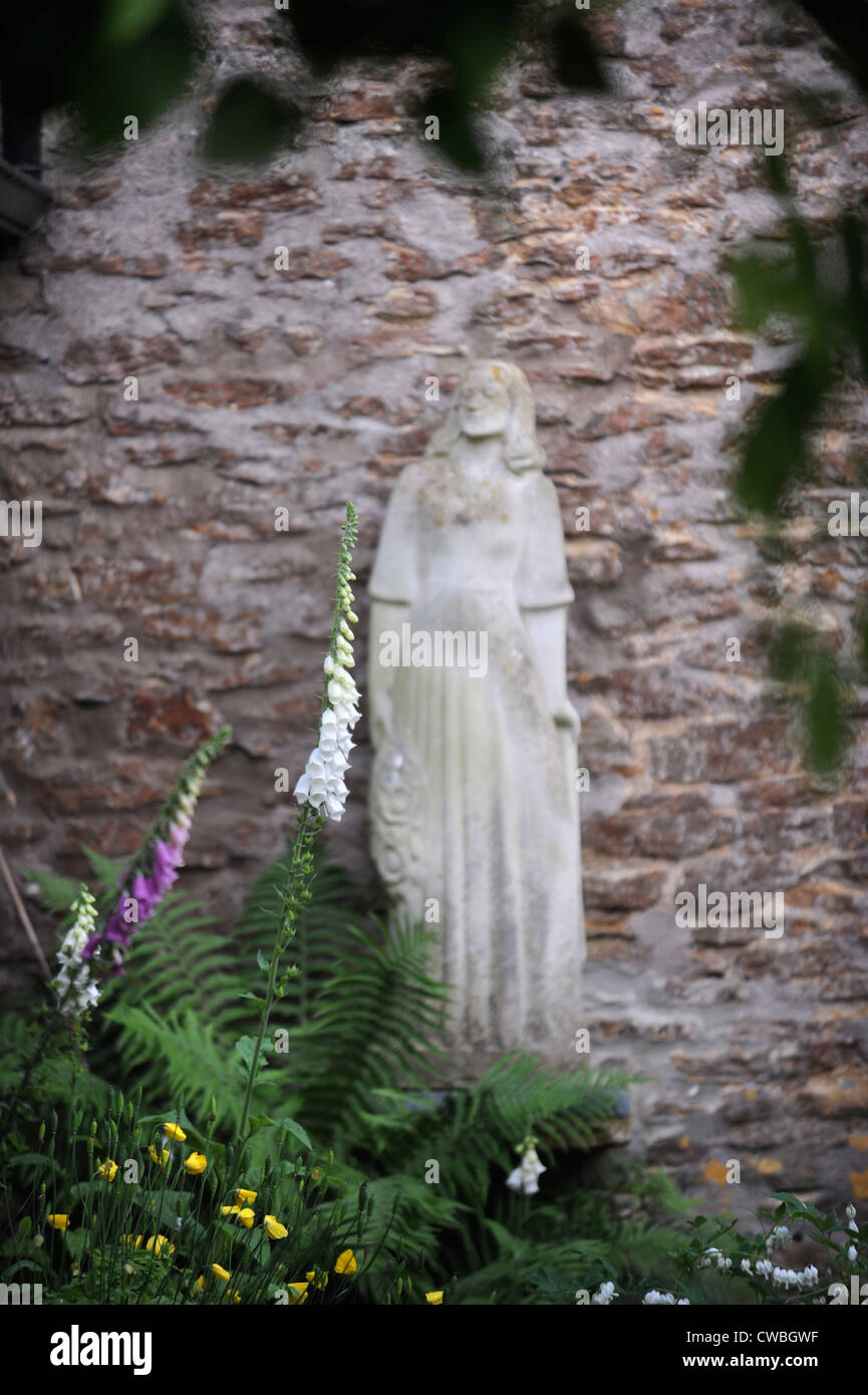 Statue in einem ummauerten Garten mit Fingerhut UK Stockfoto