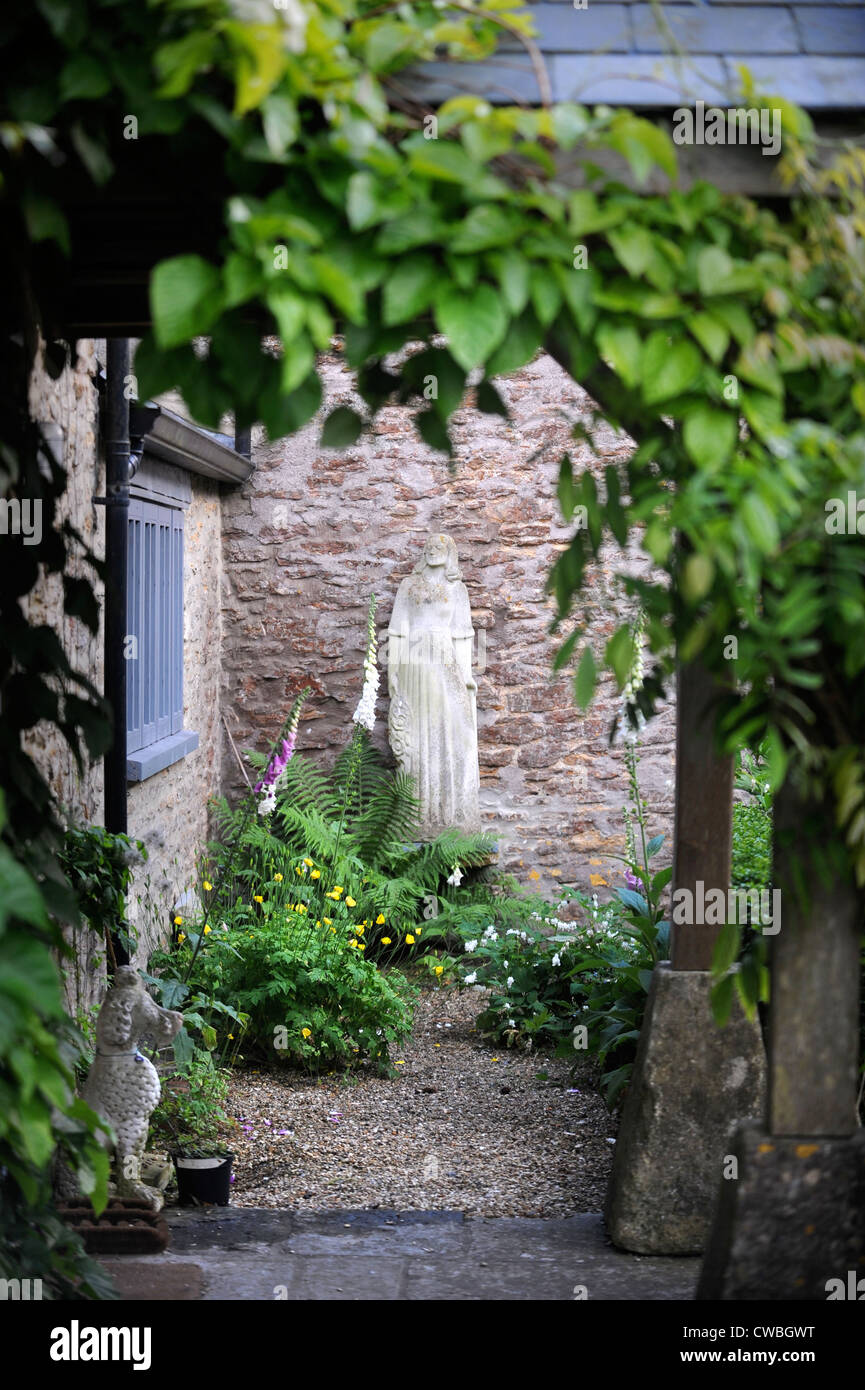 Statue in einem ummauerten Garten mit Fingerhut UK Stockfoto