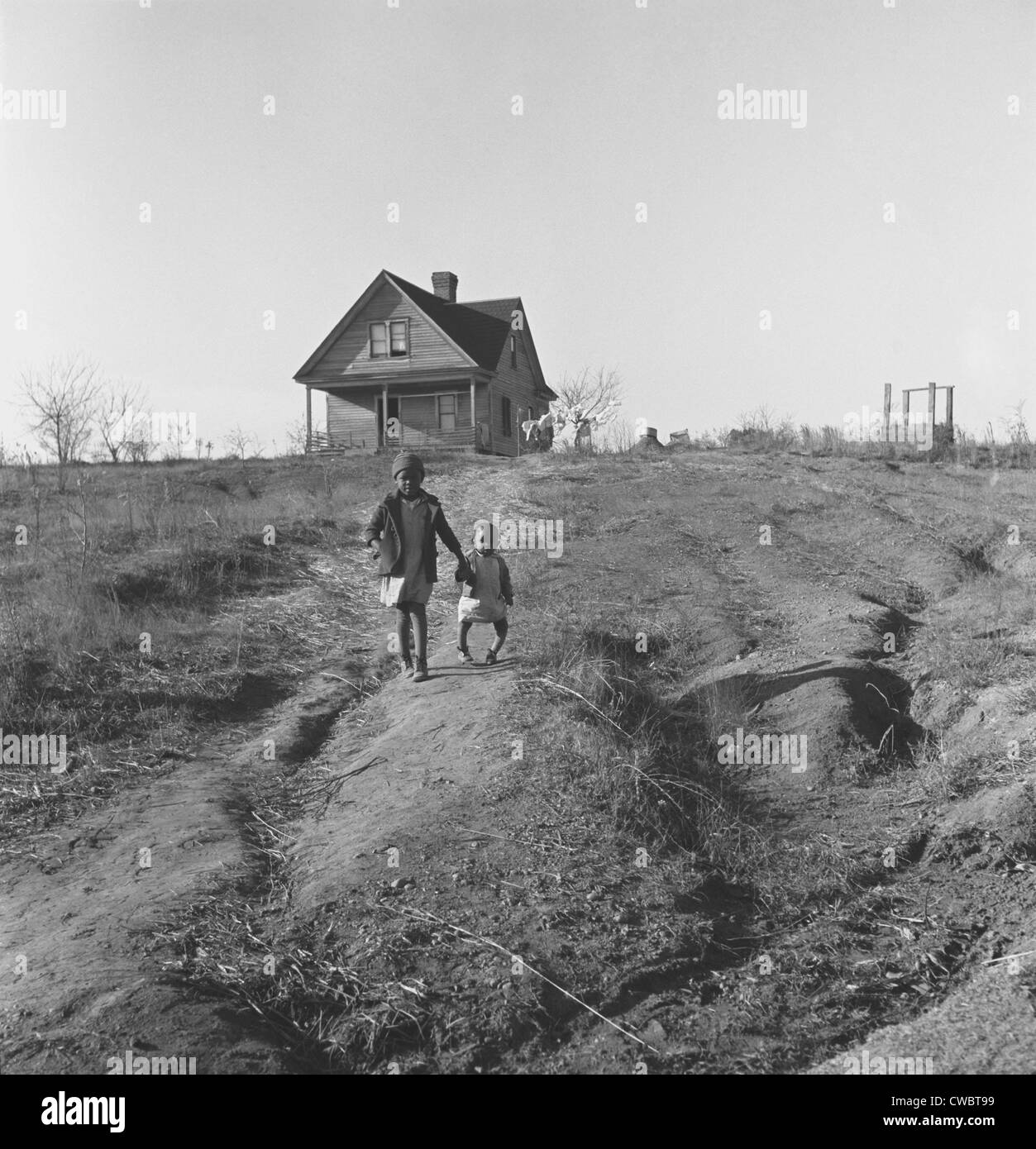 African American Kinder begehbar aus ihrer alten Heimat stark erodierten Land während der großen Depression. Das ältere Kind ist dünn, Stockfoto